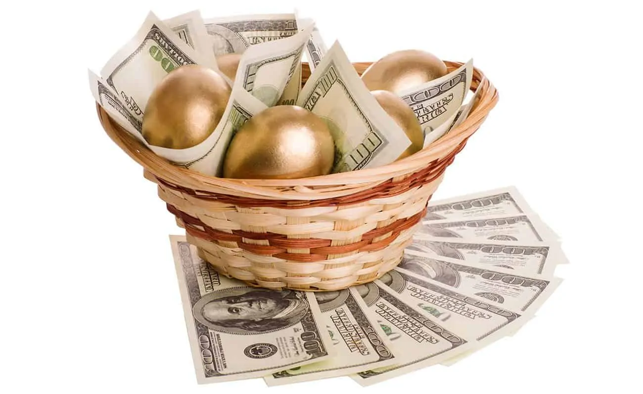 golden eggs and dollars in a basket isolated on white background